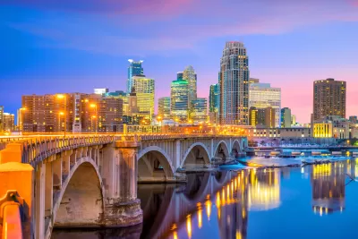 Late evening view of downtown Minneapolis skyline with stone bridge in foreground