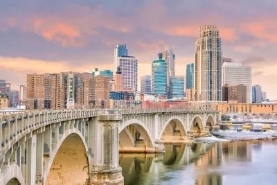 Downtown Minneapolis, Minnesota skylinw with stone arched brige in foreground.