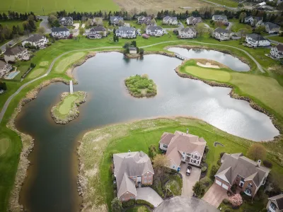 Aerial view of large suburban homes on small lake in Mount Laurel, New Jersey.