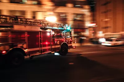 Chicago fire department fire truck driving down street with blurred background indicating motion at nighttime.