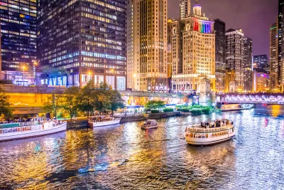 View of Chicago river and waterfront with boats at night.