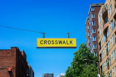 Yellow CROSSWALK sign hanging above a street in downtown Seattle, Washington.
