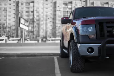 Low close-up of front of large parked pick-up truck.