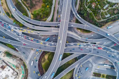 Aerial view of layered overpasses and highway intersections filled with cars.