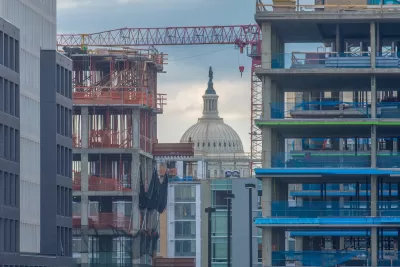View of Washington D.C. Capitol dome through high-rise buildings in various states of construction.