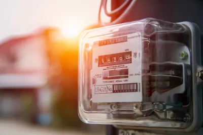 Close-up of electricity meter on house with sunset light in background.