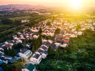 Aerial view of single-family homes in Houston suburb with setting sun in background