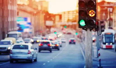 Traffic light with blurred cars and streetcar in background.