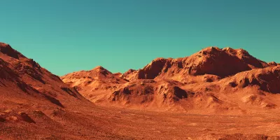 Barren rocky landscape against teal sky.