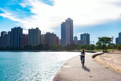 Cyclist riding along paved path at edge of Lake Michigan in Chicago, Illinois.