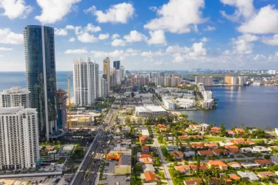 Aerial view of Miami, Florida with high-rises along beach and low-rise homes inlower right corner