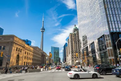 Busy street in Toronto, Canada with CN Tower visible in background.