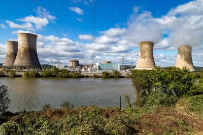 View of Three Mile Island nuclear power plant with four reactor towers on a sunny day.