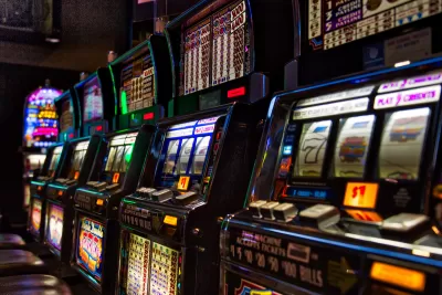 Close-up of row of slot machines in dark casino.