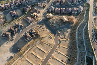 Aerial view of neighborhood under construction with houses and vacant lots.
