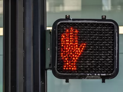 Red hand lit up as "don't walk" pedestrian signal.