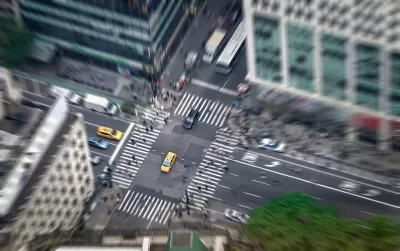 Aerial view of intersection in New York City with yellow cabs and zebra crosswalks.