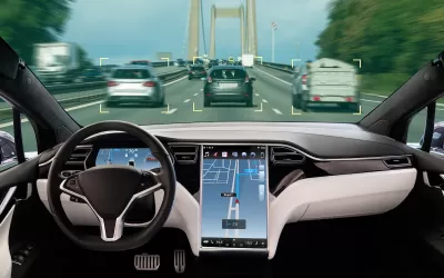 Interior of autonomous car with large map screen on road.