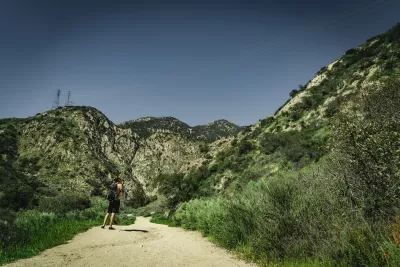 Lone hiker on gravel trail at Eaton Canyon Natural Area, Los Angeles County