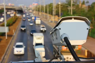Automated traffic enforcement camera mounted above roadway with blurred image of roadway and cars below