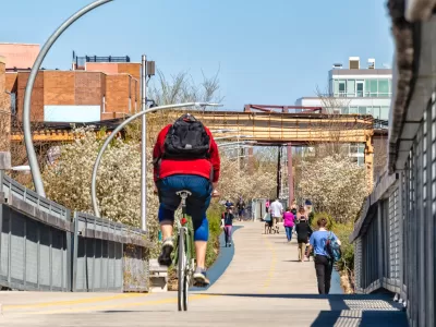 People on bikes and walking on 606 Bloomingdale Bike Trail on sunny day in Chicago, Illinois.
