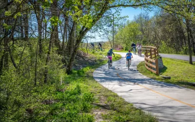 People biking on paved bike trail in Arkansas.