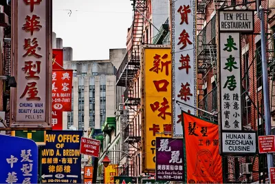 Block packed with Chinese-and English-language marquees and signs in New York City's Chinatown.