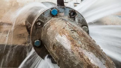 Close-up of old, rusted water pipe leaking at joint.