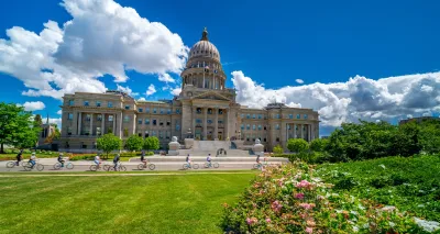 Group of bikes riding in front of Idaho State Capitol dome.