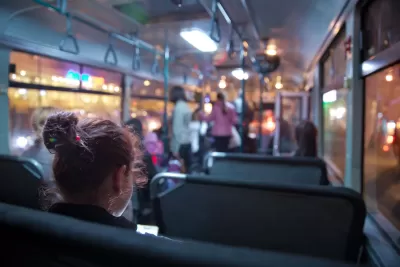 View of passengers on transit bus at night.
