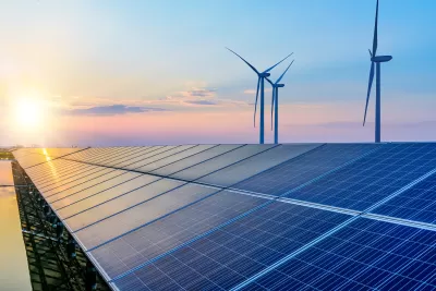 Solar panels and wind turbines against sunset colors