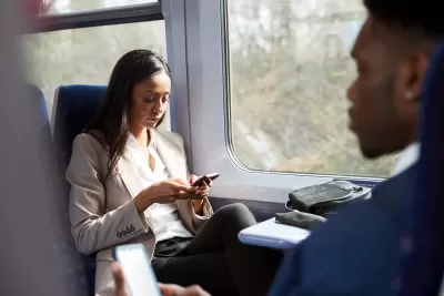 Close-up of two passengers in business clothes sitting face to face on speeding train