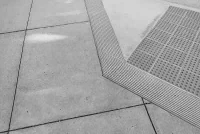 Grey concrete curb ramp with small bumps for the visually impaired.
