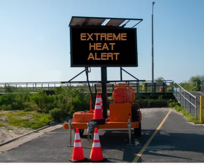 Road sign with EXTREME HEAT ALERT surrounded by orange traffic cones