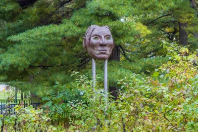 Bronze or metal Native American mask sculpture in park in Minnehaha County.