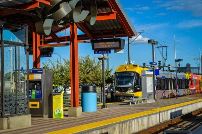 Yellow and silver Metro Transit light rail train pulling into outdoor station in Minneapolis, Minnesota.