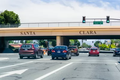 Cars passing under 101 freeway overpass with SANTA CLARA in large letters on the overpass