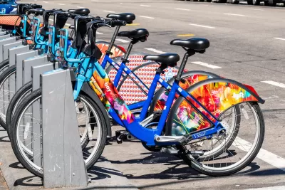 Bay Wheels bike share station full of colorful parked bikes on San Francisco street.