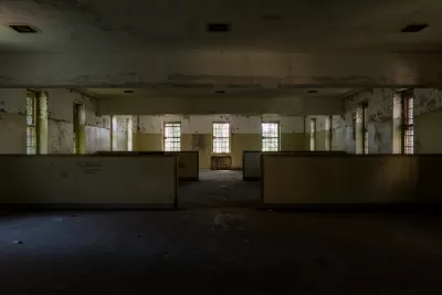 Abandoned wing of Creedmoor Hospital, Queens New York with long row of windows and 'Reading Room' visible on wall