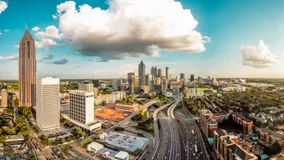 Birds-eye view of Atlanta skyline and highway running through the middle of it.