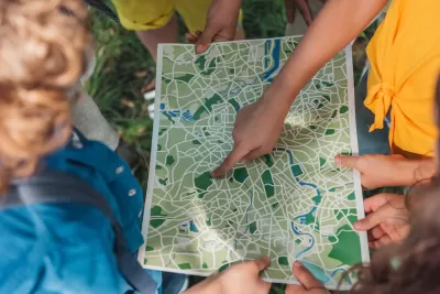 Group of children looking down at map.