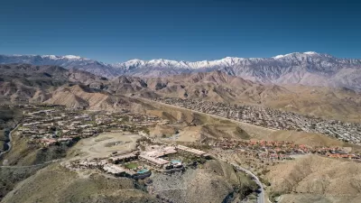 Aerial view of Rancho Mirage, California with homes in foreground and snowy San Gabriel Mountains in background.