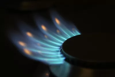 Close-up of natural gas stove burner with blue flames.