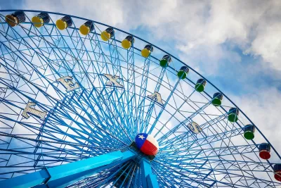 Blue Ferris wheel with Texas state Lone Star logo in middle of wheel.