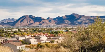View of large homes in Henderson, Nevada with desert mountains in background.