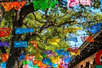Colorful paper banners strung across street in historic tourist neighborhood in San Antonio, Texas.