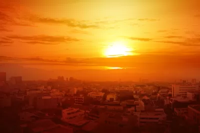 View of city skyline with orange sky indicating extreme heat.