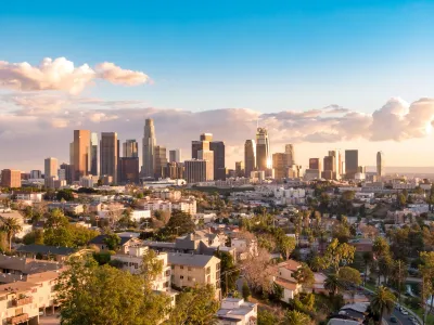Downtown Los Angeles skyline viewed from the northwest on a sunny day with scattered clouds.