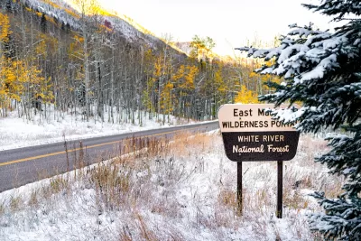 Maroon Bells sign for wilderness portal and white river national forest in Aspen, Colorado rocky mountain covered in snow after winter frozen in autumn 2019.