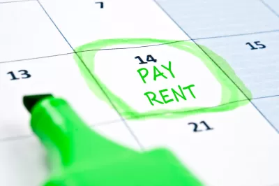 Close-up of calendar with "Pay rent" written on day 14 and circled in green highlighter